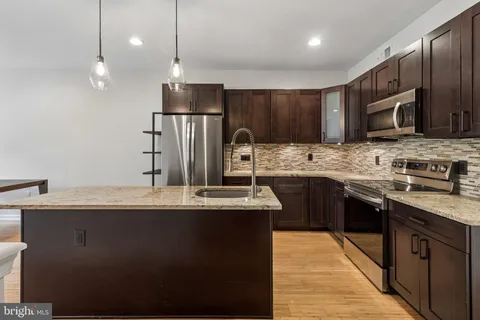 a kitchen with granite countertop wooden cabinets and stainless steel appliances