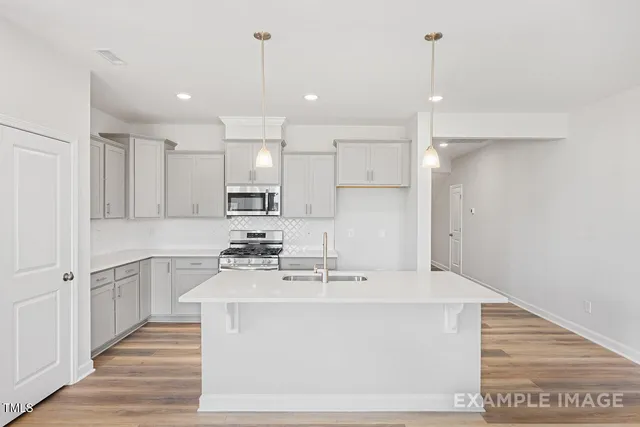 a kitchen with kitchen island a sink stainless steel appliances and cabinets