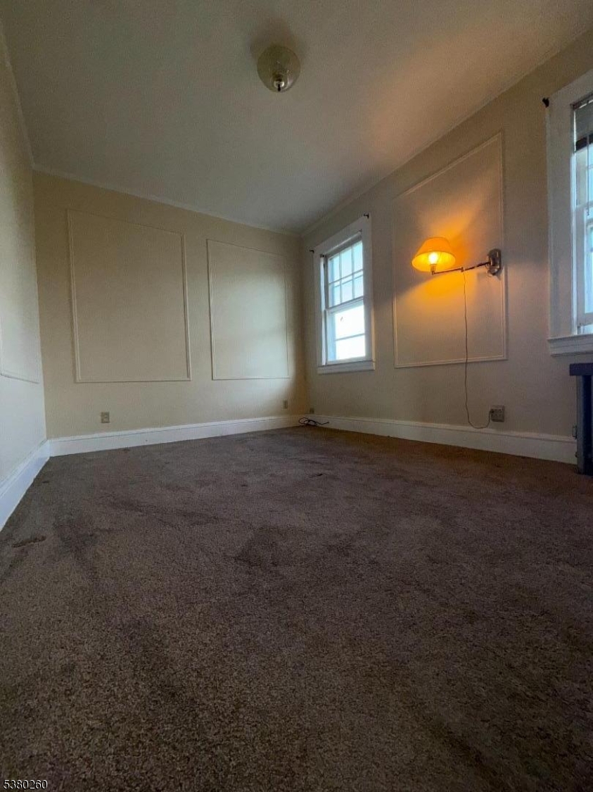 313 Ashton Avenue, Unit 2 Linden, NJ 07036 - Photo 7 of 8 an empty room with a empty space and windows