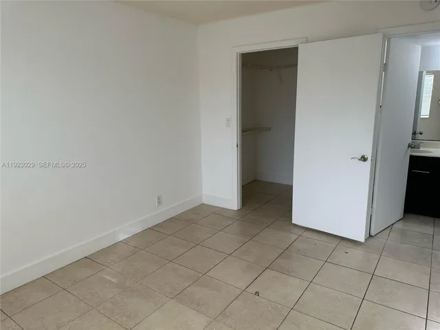 an empty room with closet and a ceiling fan