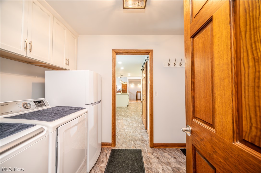 405 Airport Road Northwest Warren, OH 44481 - Photo 21 of 50 Laundry space featuring white upper cabinetry, a refrigerator, and wood door.