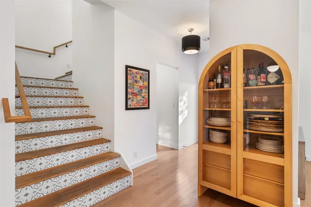 a view of a hallway with wooden floor and windows