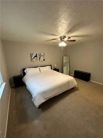 a bedroom with a bed and a ceiling fan