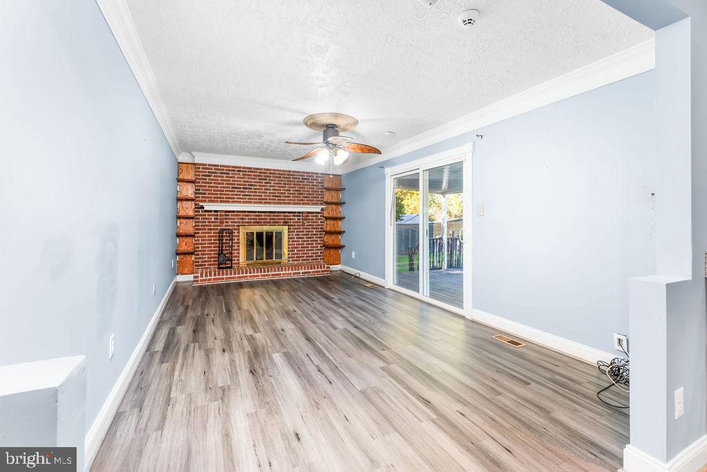 4924 Plata Street Clinton, MD 20735 - Photo 7 of 26 a view of an empty room with wooden floor fireplace and a window