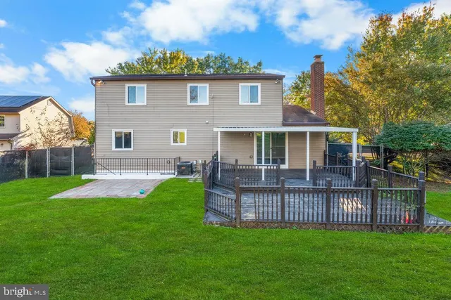 a view of a house with a yard and a deck