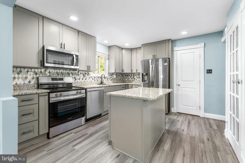 4924 Plata Street Clinton, MD 20735 - Photo 9 of 26 a kitchen with kitchen island granite countertop a sink stainless steel appliances and cabinets