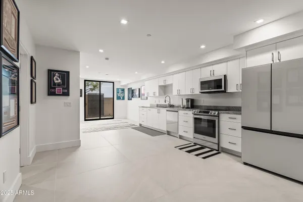 a bedroom with a bed and a flat tv screen on dresser