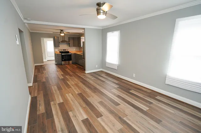 a view of empty room with wooden floor