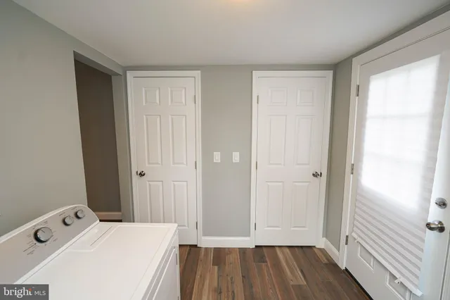 a view of a bathroom with baby crib and wooden floor