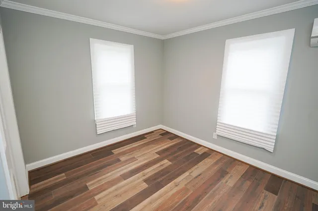 a view of empty room with wooden floor