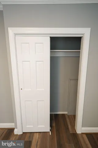 a view of closet area with hardwood floor