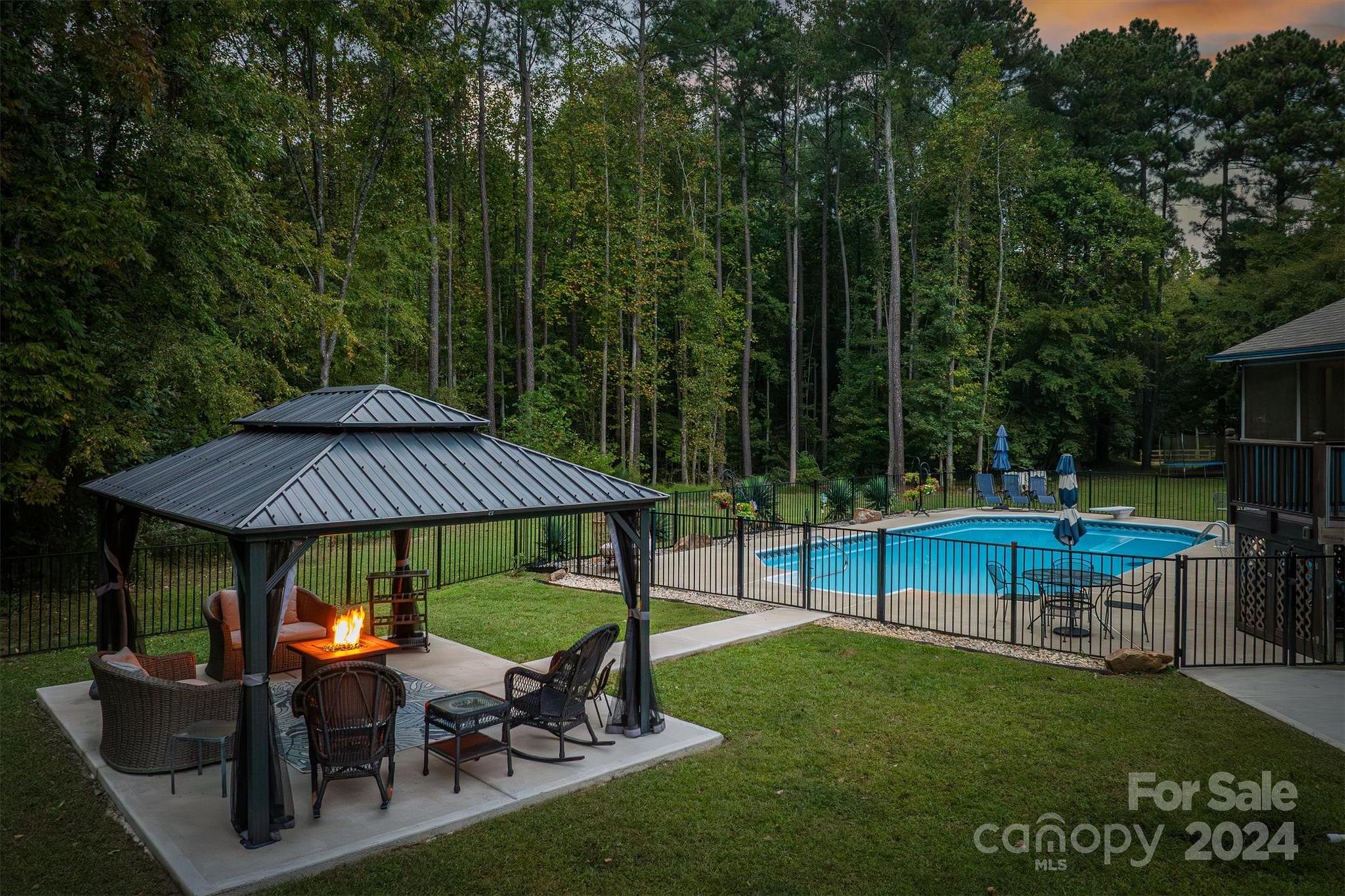 8800 Flowes Store Road Concord, NC 28025 - Photo 4 of 48 a view of backyard with table and chairs under an umbrella