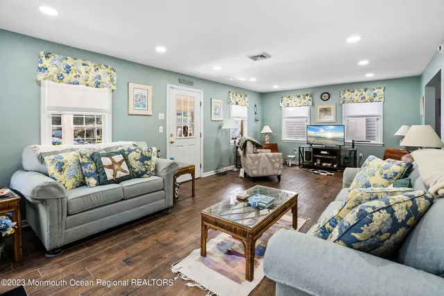 a living room with furniture and a flat screen tv with wooden floor