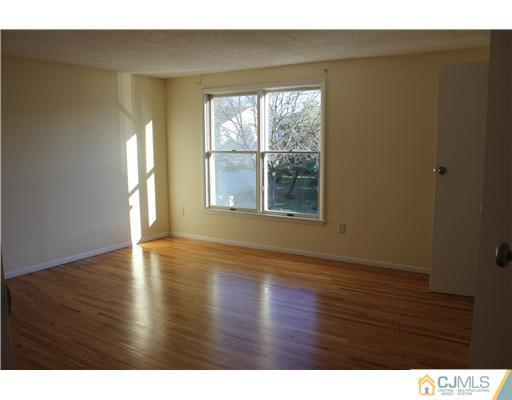 4407 Hana Road Edison, NJ 08817 - Photo 7 of 10 a view of an empty room with wooden floor and a window
