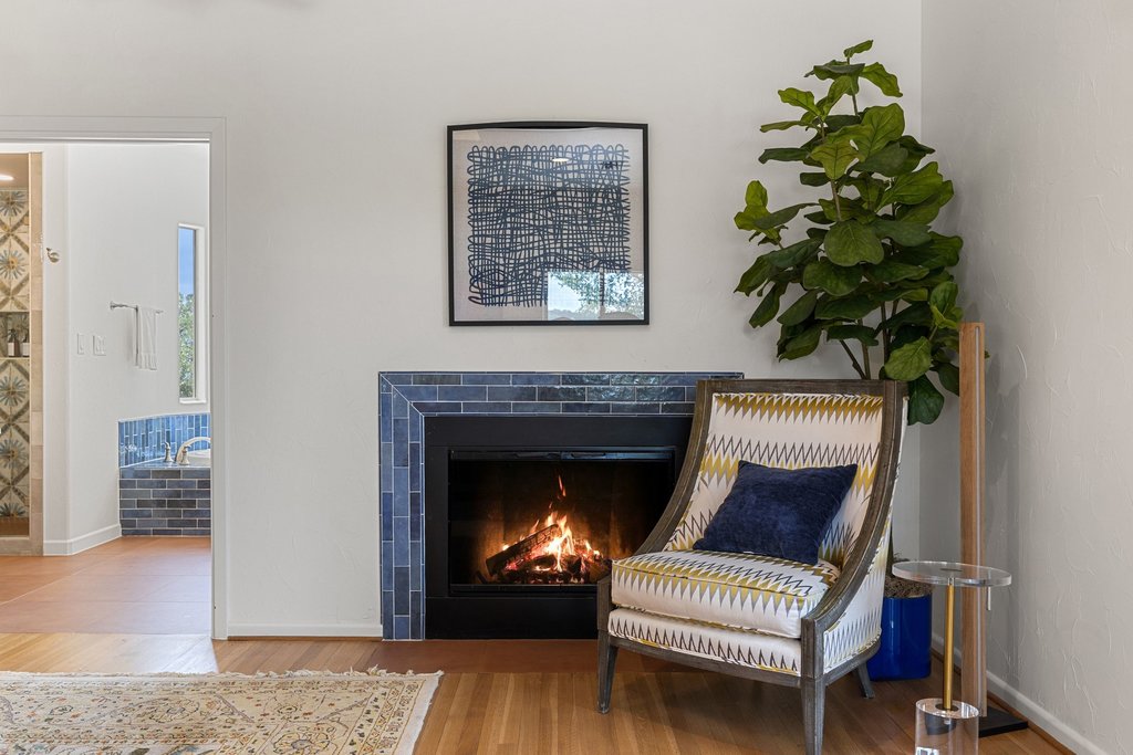 716 North Commons Ford Road Austin, TX 78733 - Photo 11 of 30 Fireplace featuring blue subway tile surround and black hearth