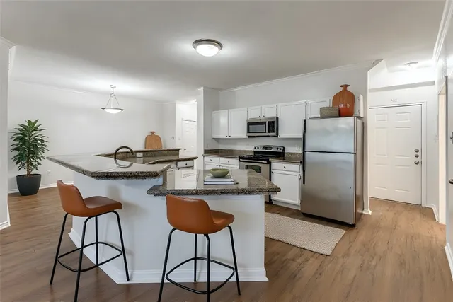 a kitchen with stainless steel appliances a refrigerator and a stove top oven
