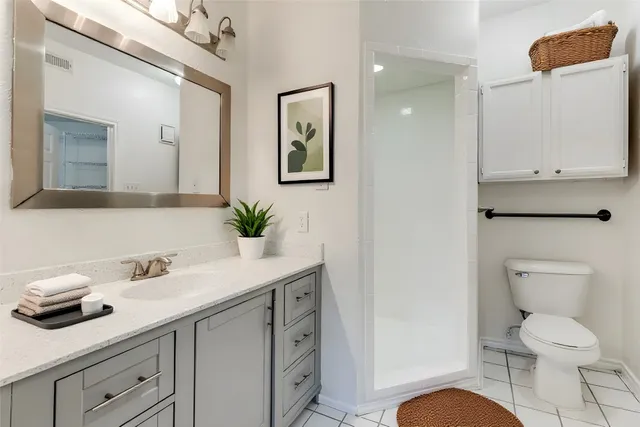 a bathroom with a granite countertop toilet sink and mirror