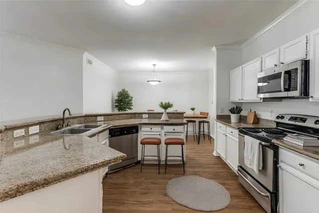 a kitchen with a table chairs stove and cabinets