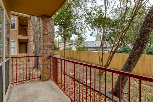 a view of a balcony with wooden floor and fence