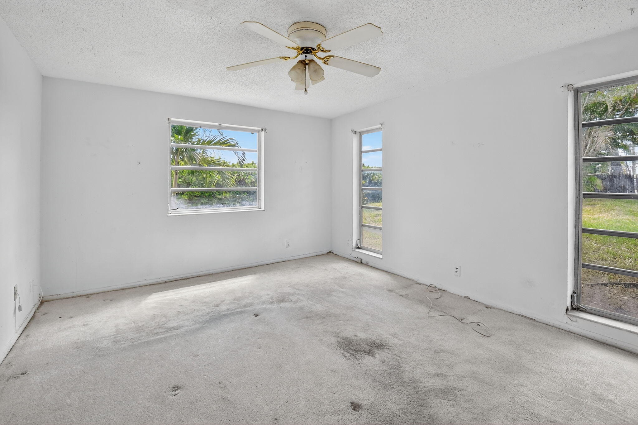 13682 Vía Flora, Unit D Delray Beach, FL 33484 - Photo 13 of 27 an empty room with windows and ceiling fan