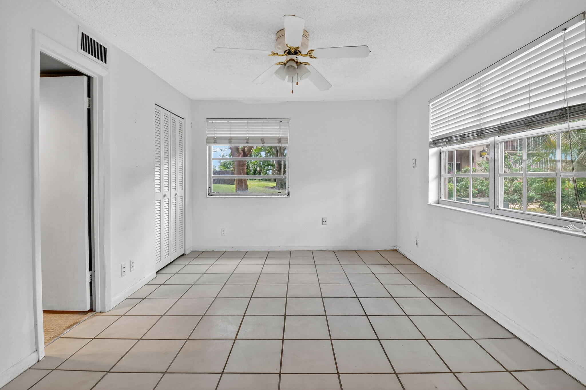13682 Vía Flora, Unit D Delray Beach, FL 33484 - Photo 17 of 27 an empty room with windows and closet