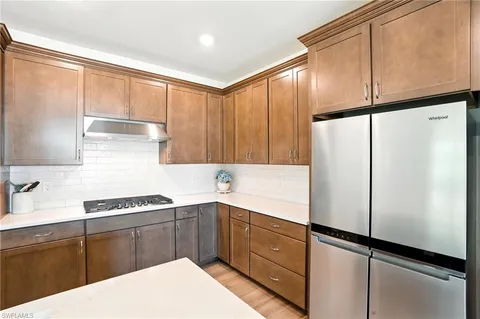 a kitchen with a refrigerator a sink and cabinets