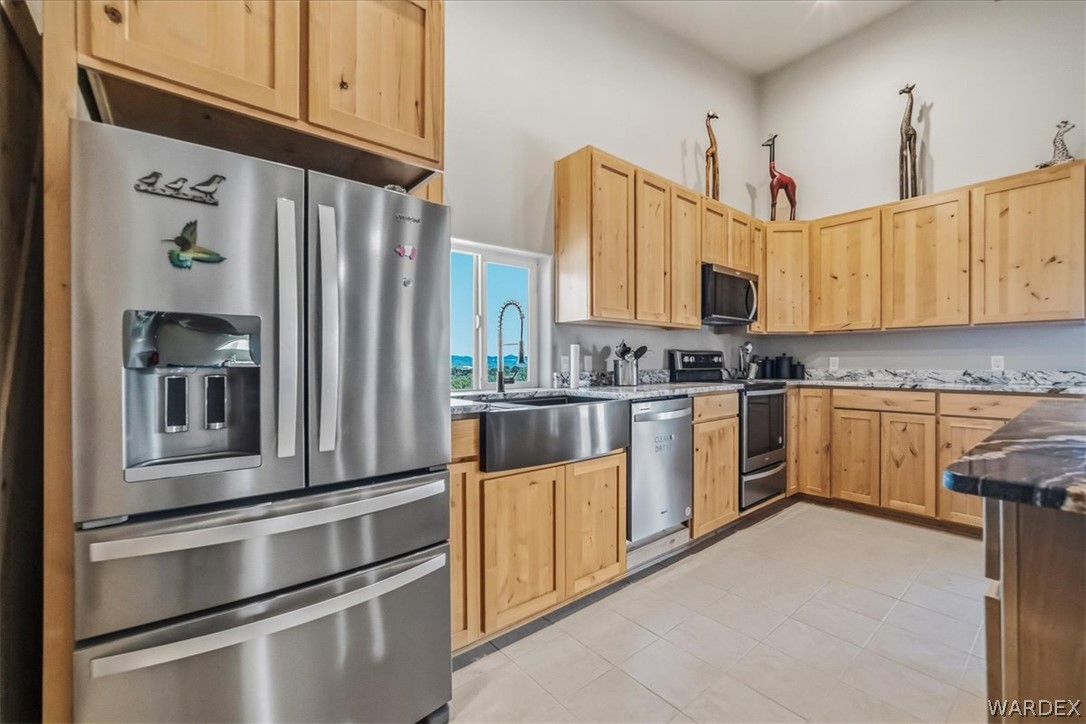 10374 East Happy Trails Road Kingman, AZ 86401 - Photo 18 of 68 a kitchen with a refrigerator and cabinets
