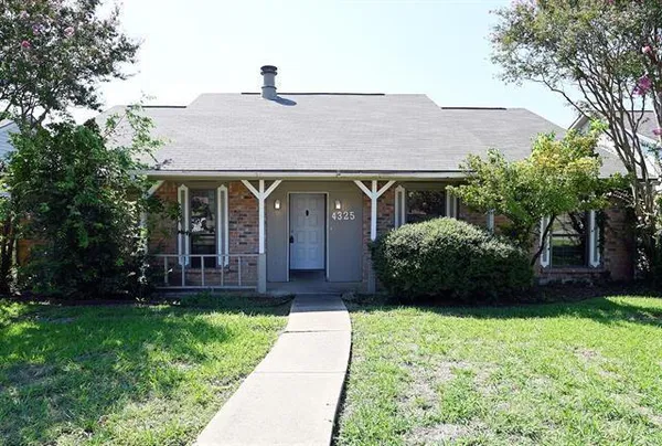 a front view of a house with a garden and plants