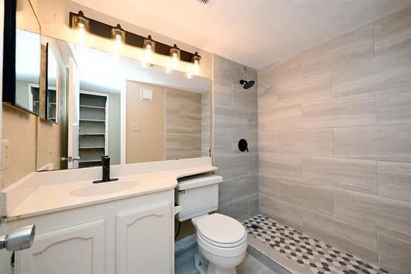 a bathroom with a sink a toilet and shower