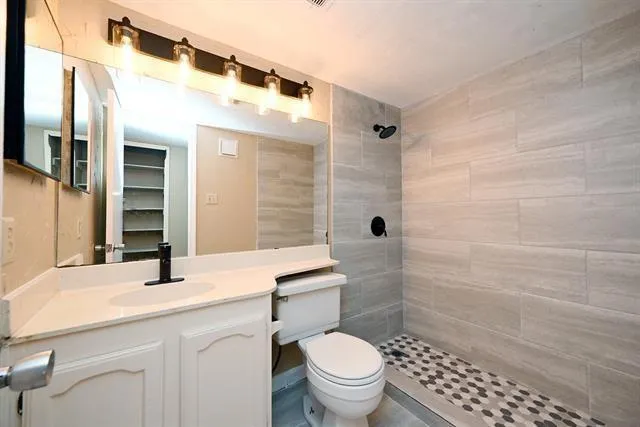 a bathroom with a sink a toilet and shower
