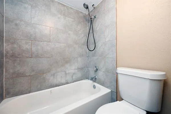 a white bath tub sitting next to a toilet