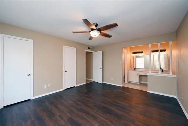 a view of an empty room with window and wooden floor