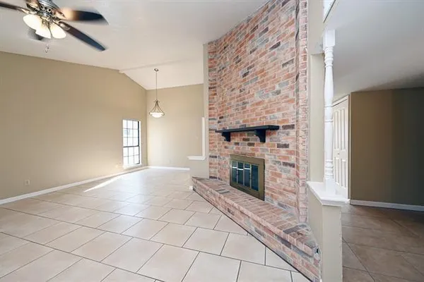 a view of empty room with fireplace and fan