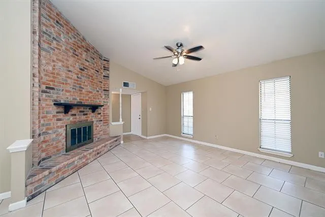 a view of empty room with windows and fireplace
