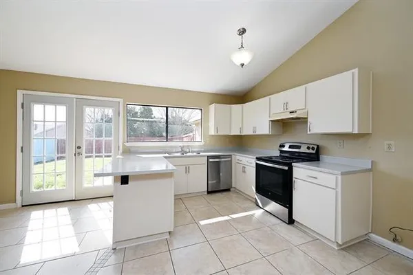 a kitchen with a stove sink and cabinets