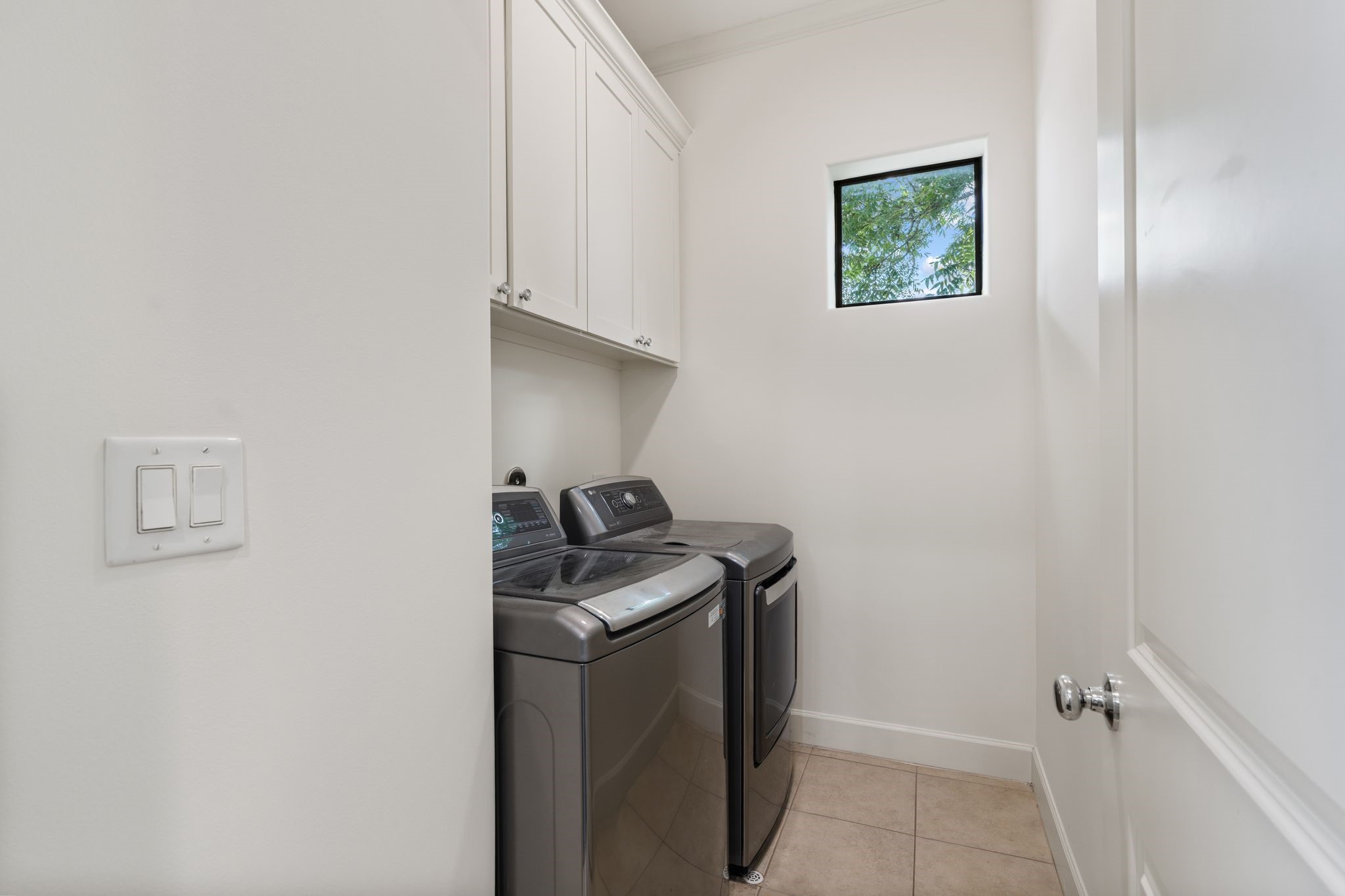 908 Thompson Street Houston, TX 77007 - Photo 25 of 45 The third-floor laundry room features LG washer and dryer units, and built-in upper cabinetry for extra storage.