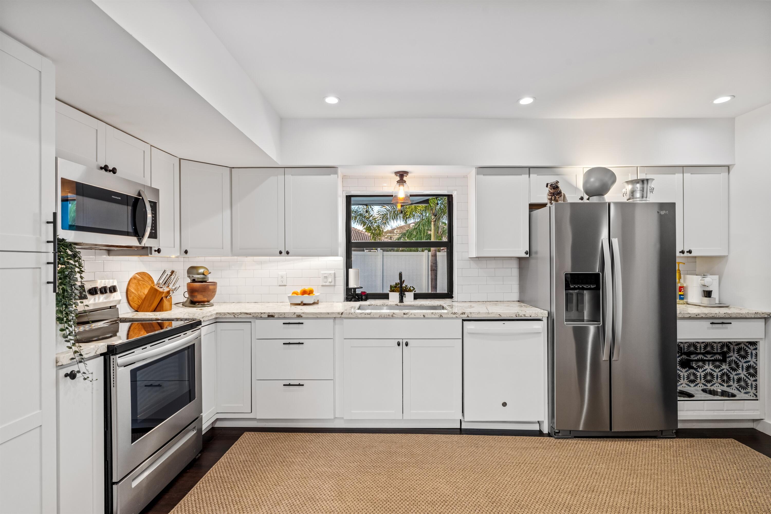 833 Northwest 6th Terrace Boca Raton, FL 33486 - Photo 15 of 49 a kitchen with stainless steel appliances a stove refrigerator sink and microwave