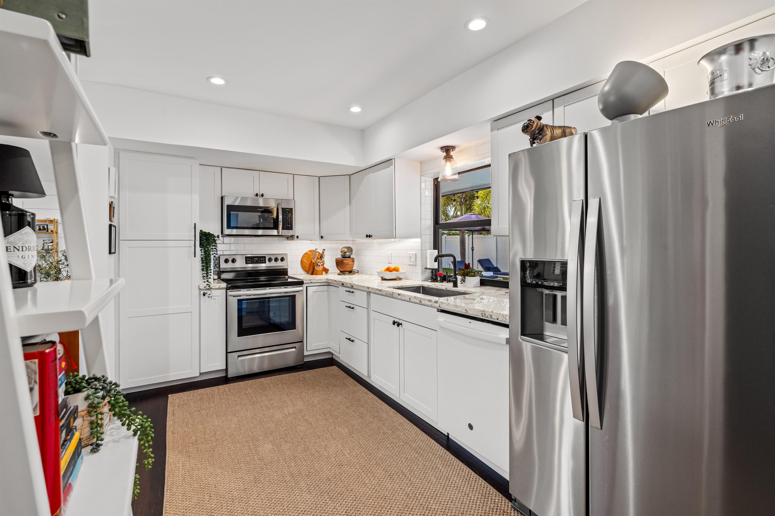 833 Northwest 6th Terrace Boca Raton, FL 33486 - Photo 16 of 49 a kitchen with refrigerator a microwave and cabinets