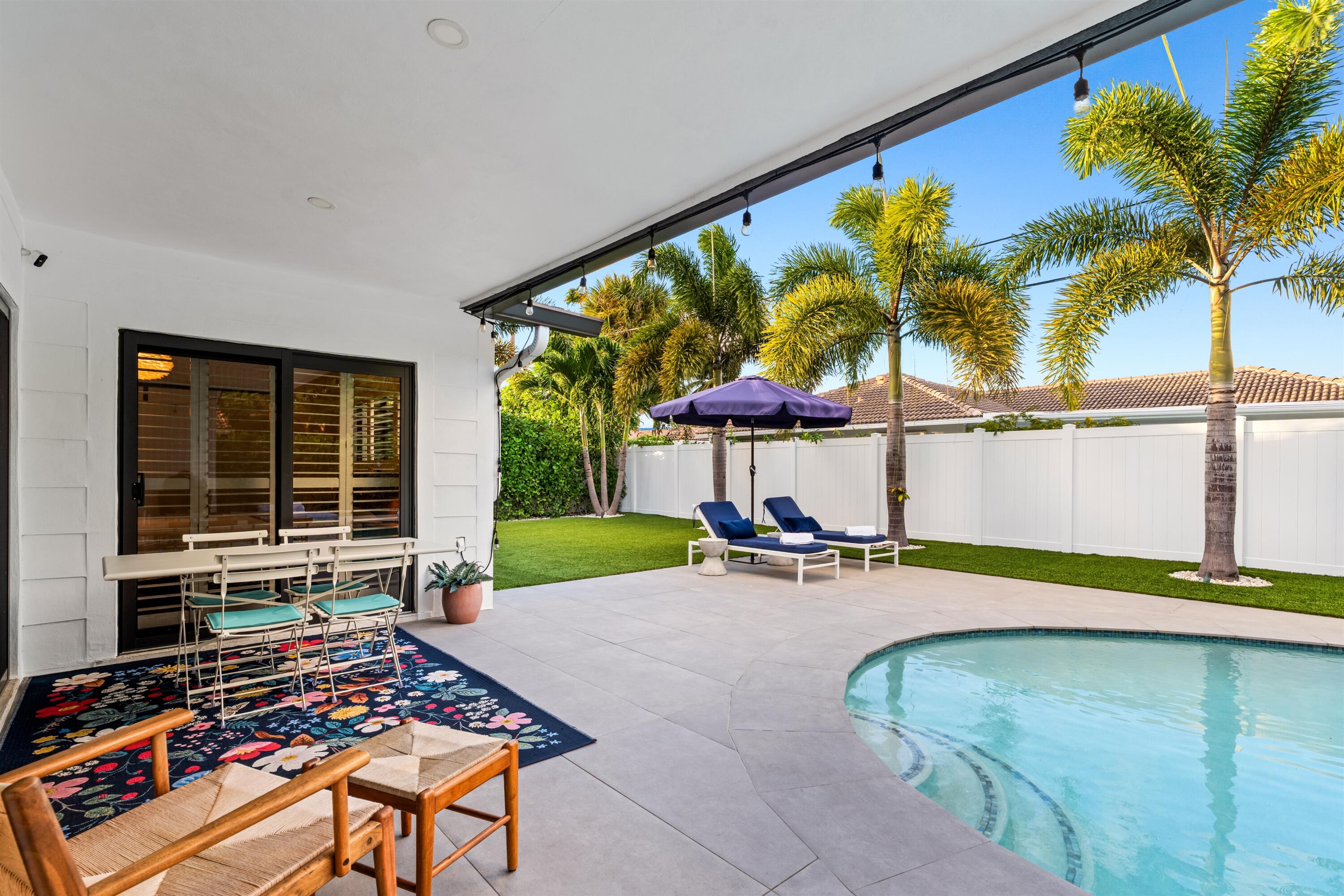 833 Northwest 6th Terrace Boca Raton, FL 33486 - Photo 34 of 49 a backyard with a table and chairs under an umbrella