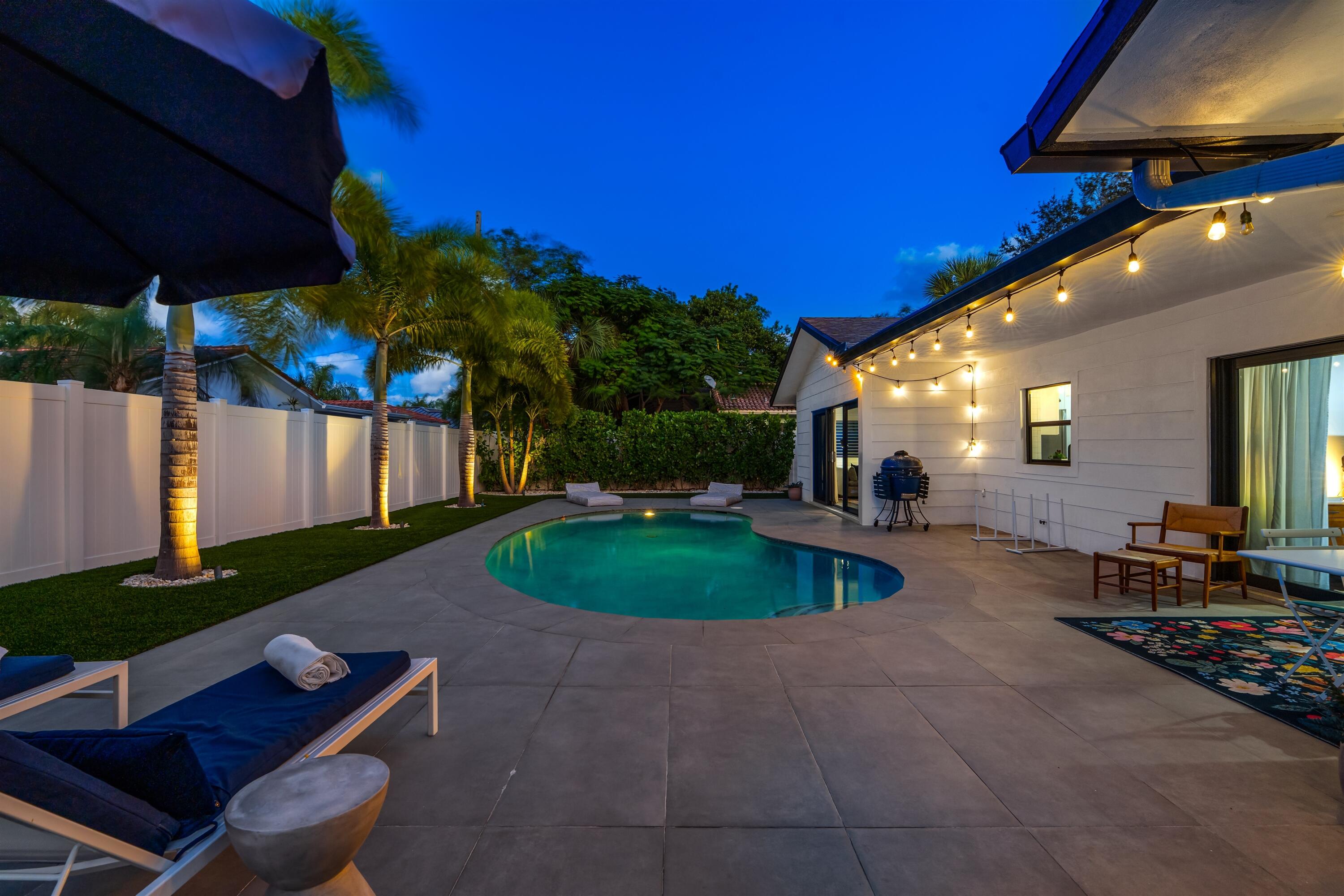 833 Northwest 6th Terrace Boca Raton, FL 33486 - Photo 36 of 49 a view of a backyard with table and chairs under an umbrella