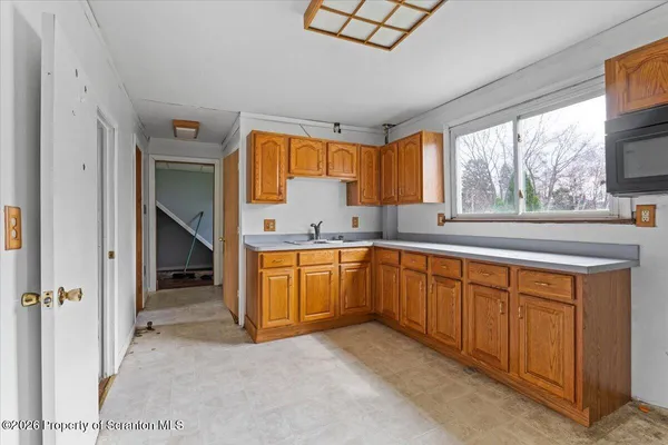 a view of a kitchen with wooden cabinets and a sink