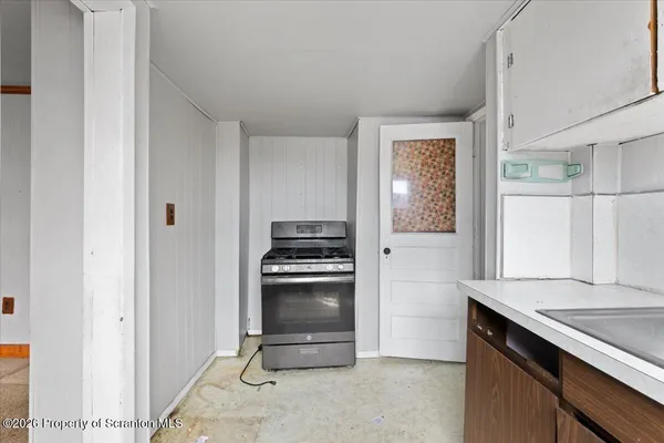 a view of empty room with windows and ceiling fan