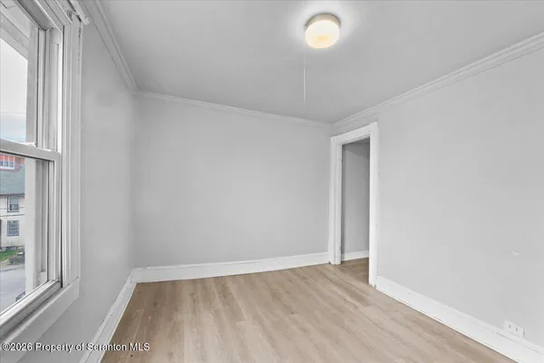 an empty room with windows and closet