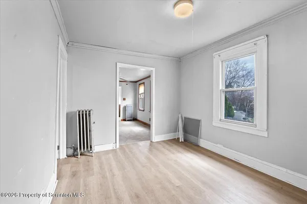 a view of a room with wooden floor and windows