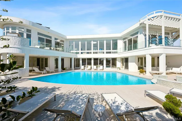 a view of a house with pool and sitting area
