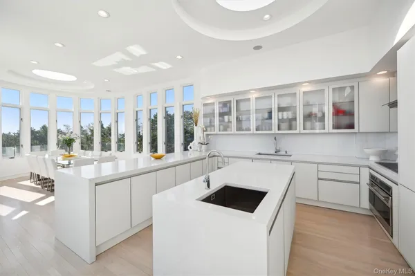 a kitchen with stainless steel appliances a white table chairs and a refrigerator