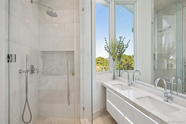 a bathroom with a double vanity sink toilet and shower