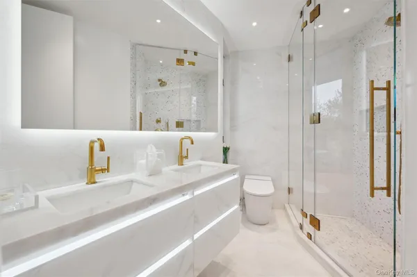 a bathroom with a sink a toilet and shower