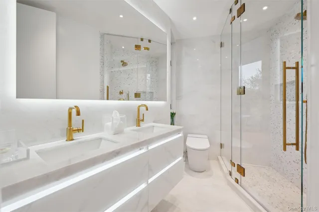 a bathroom with a sink a toilet and shower