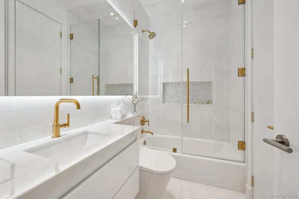 a bathroom with a granite countertop sink a toilet and shower